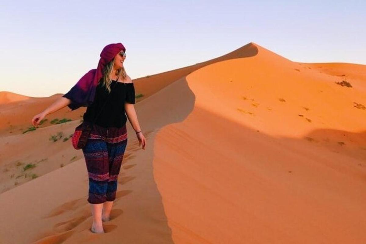 eine Frau, die auf einer Sanddüne in der Wüste läuft
