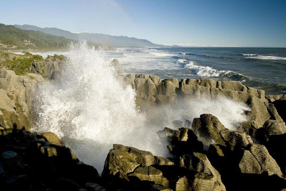 a wave crashing on the rocks near the ocean