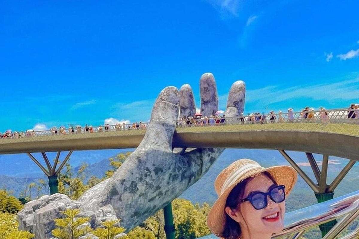 žena stojící vedle mostu s velkou rukou
