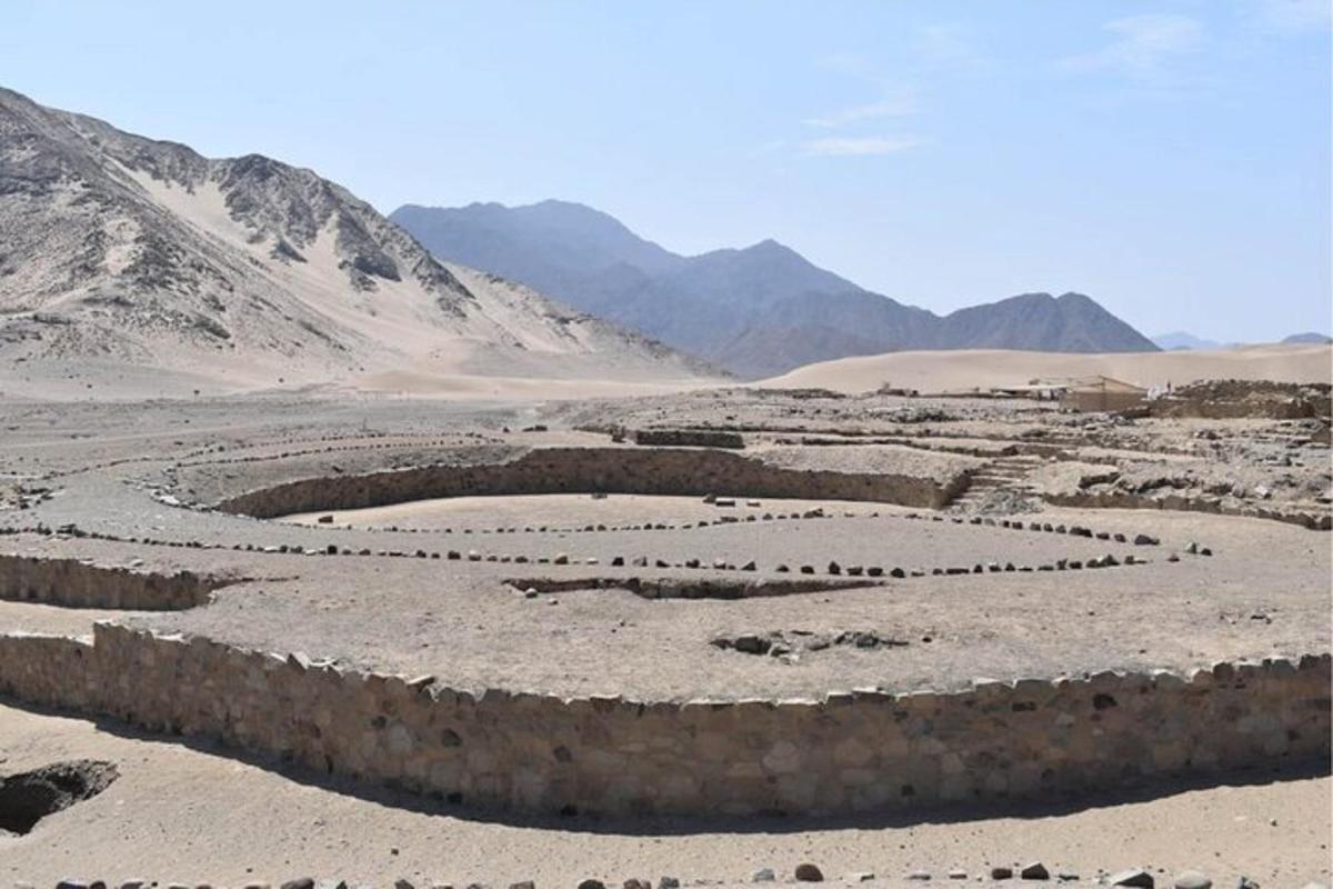an amphitheater in the desert with mountains in the background