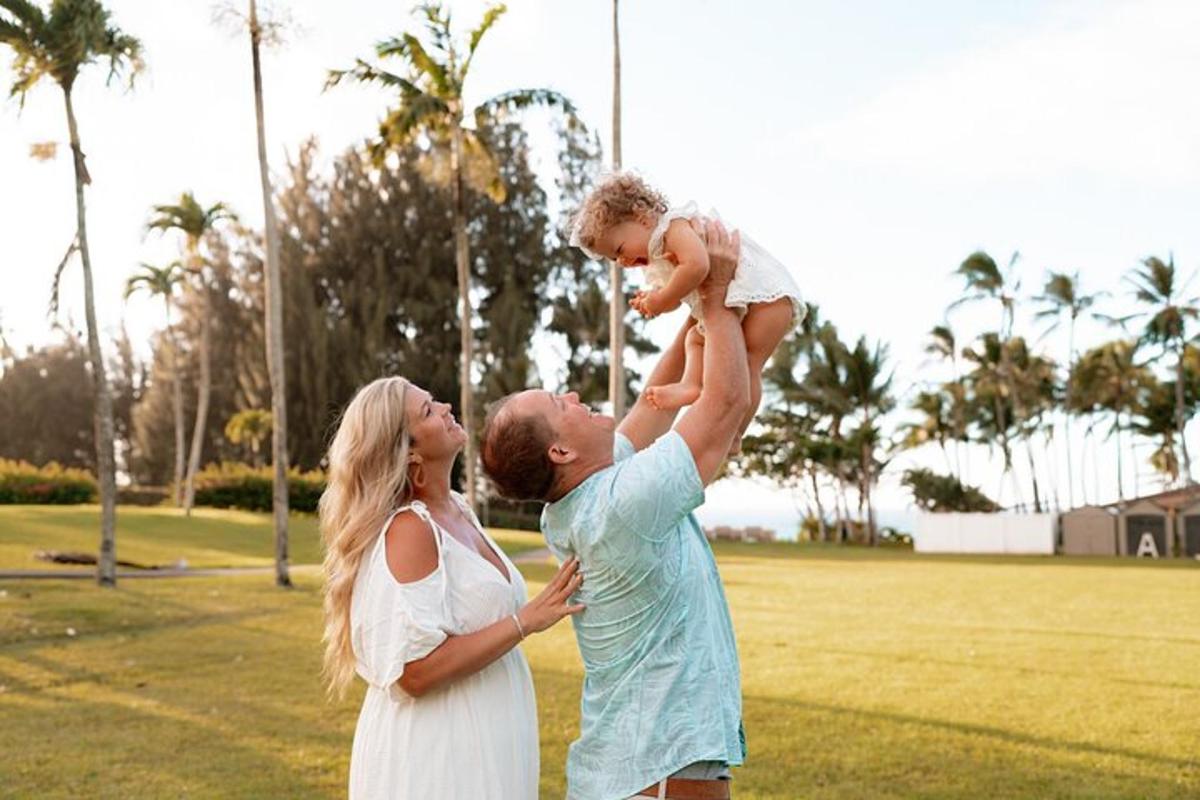 a man and a woman holding a child in the air