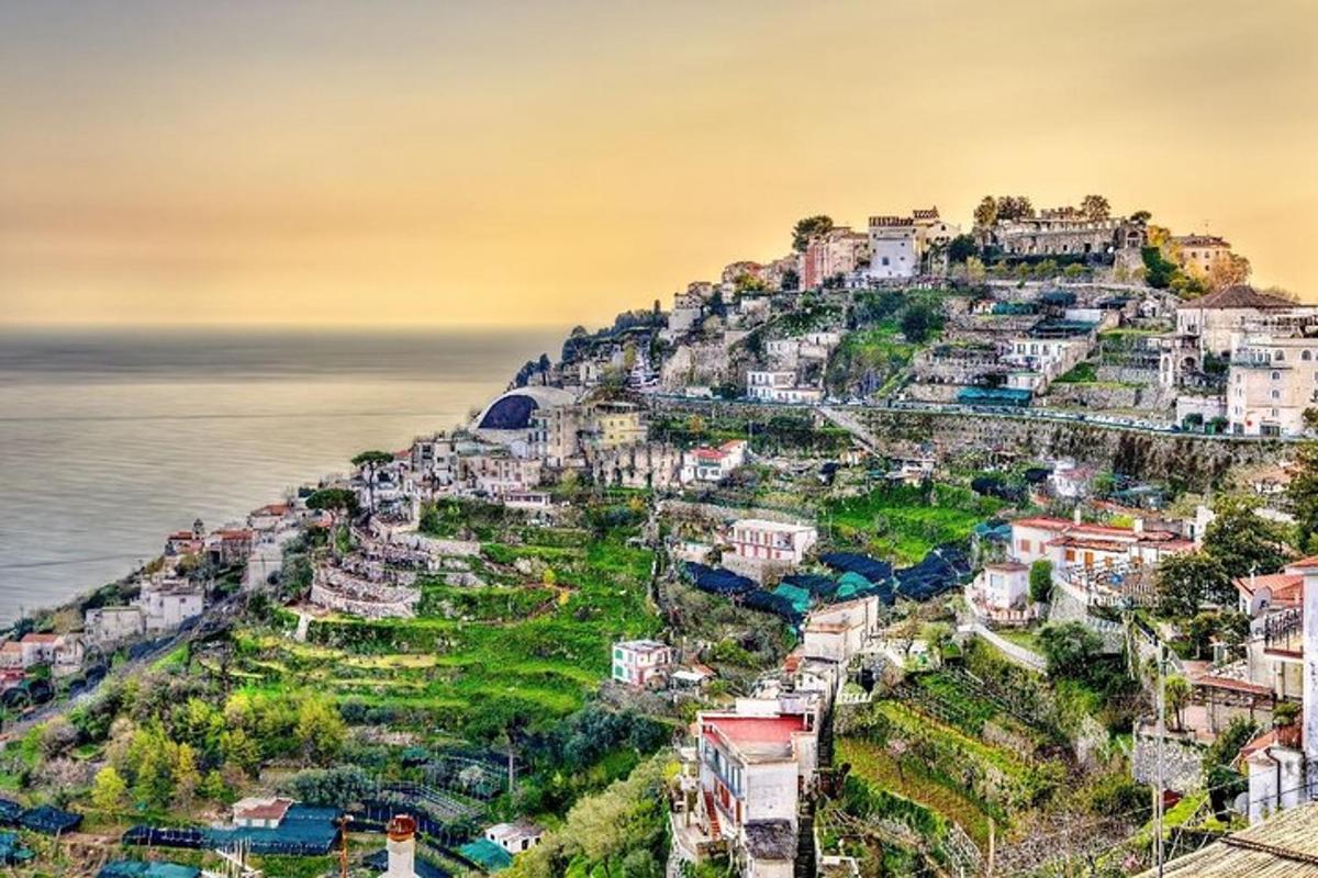 a town on a hill next to the ocean