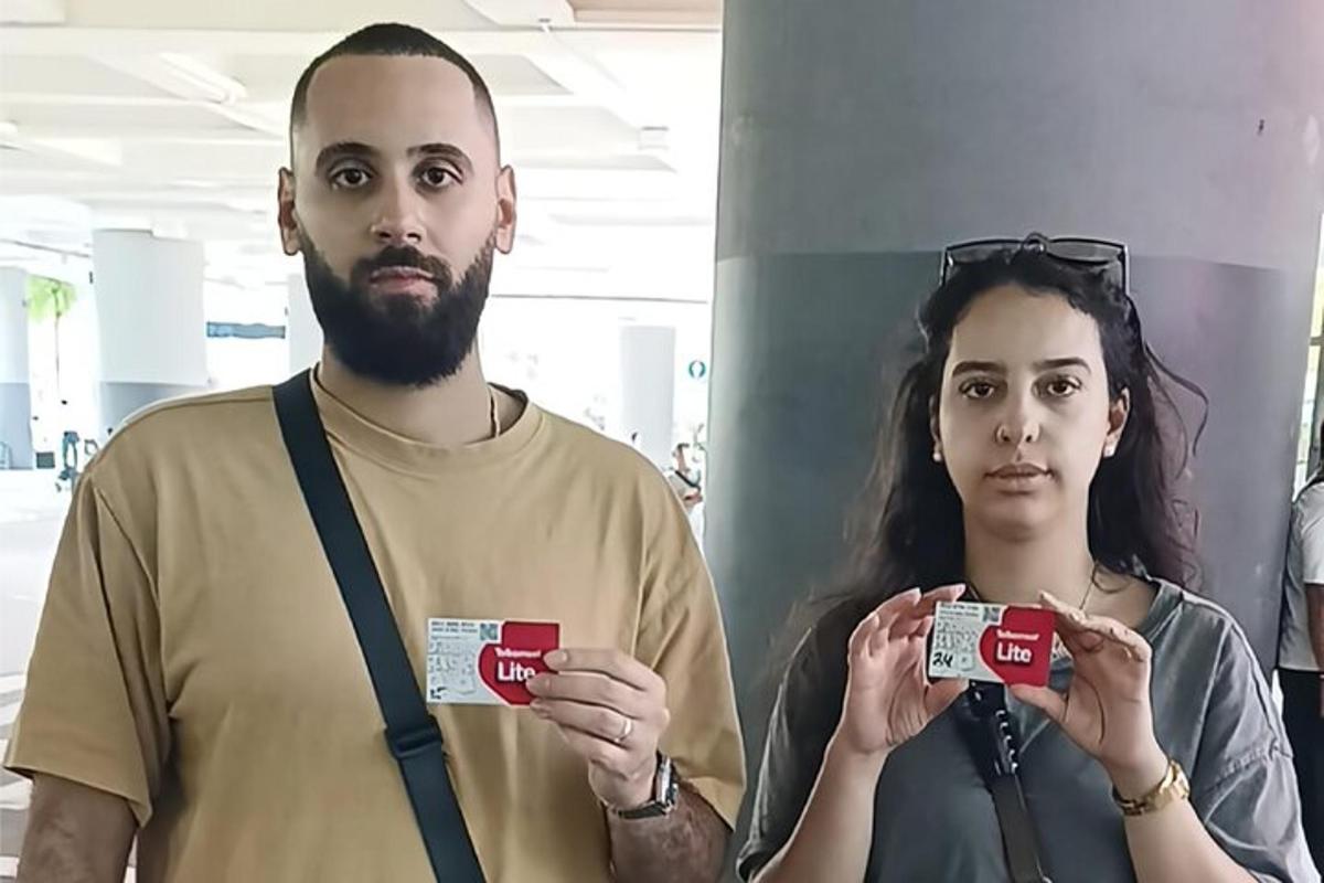 un uomo e una donna che tengono in mano due carte di credito