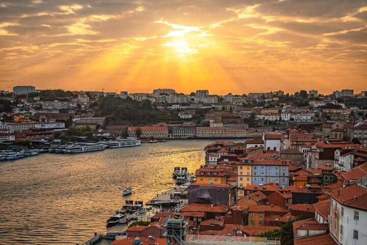 ein Sonnenuntergang über einer Stadt mit einem Fluss und Gebäuden