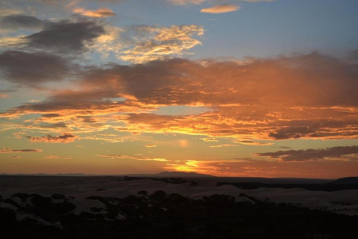 a sunset in the desert with clouds in the sky