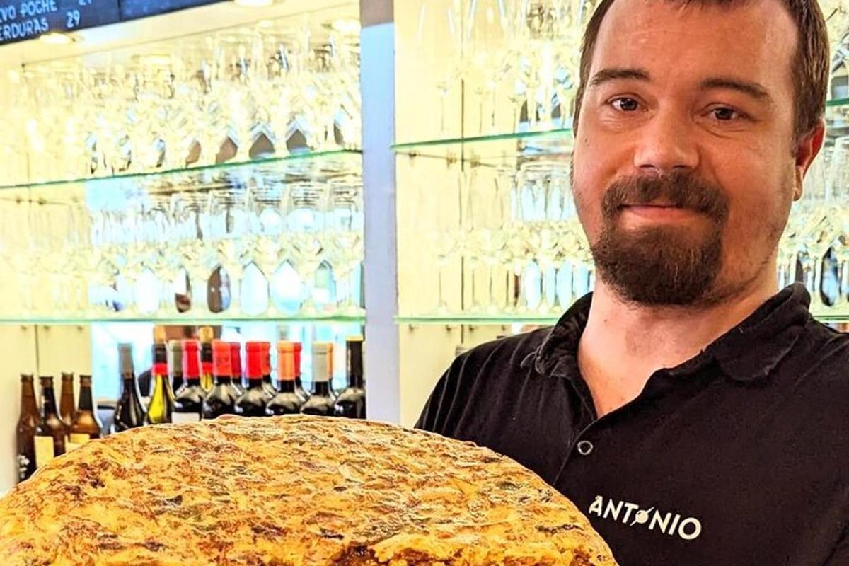 一名男子在商店里拿着一个大披萨