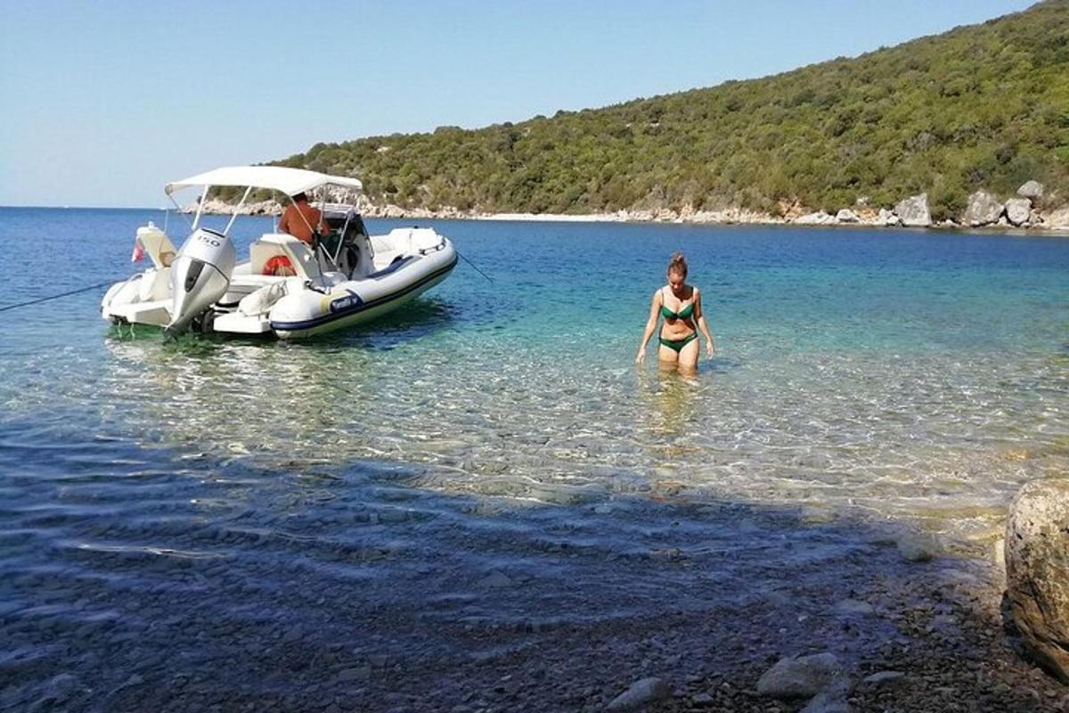 una donna in piedi nell'acqua accanto a una barca