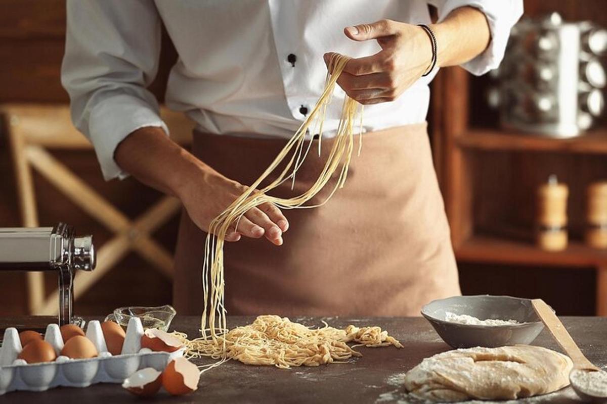 una persona in cucina che prepara il cibo con la pasta