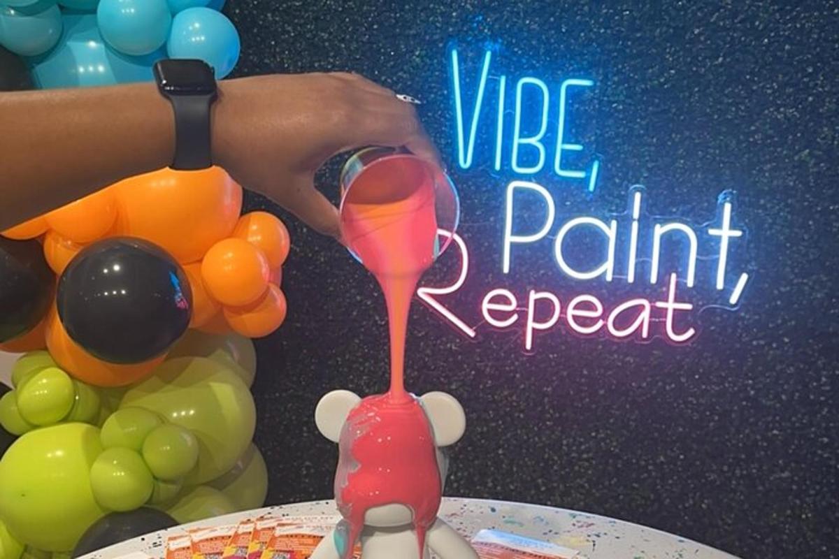 a person holding a wine glass next to a table with balloons