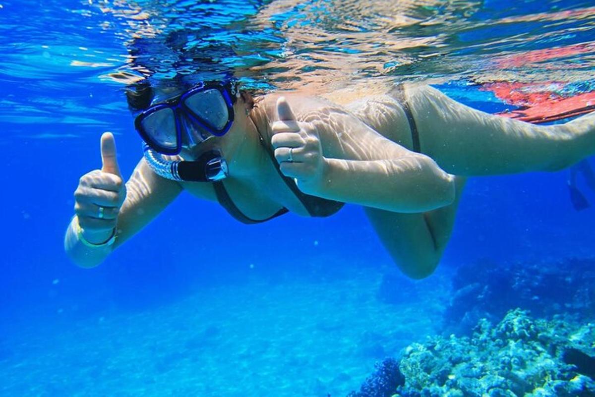 uma mulher fazendo sinal de positivo enquanto nada na água