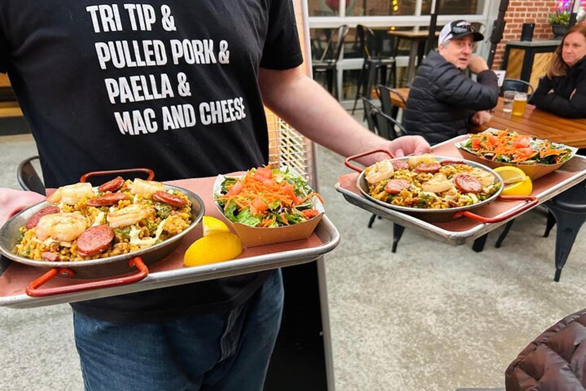 a man holding two trays of food on a table