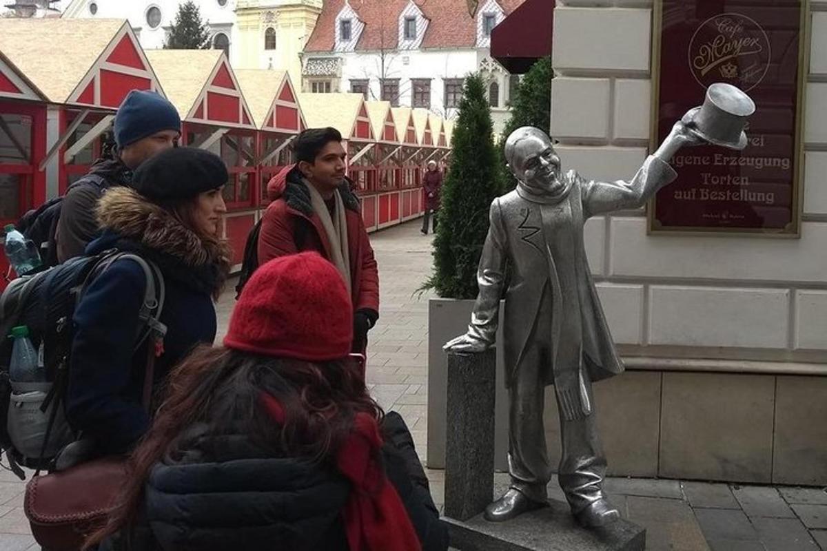 Un grupo de personas mirando una estatua de un hombre.