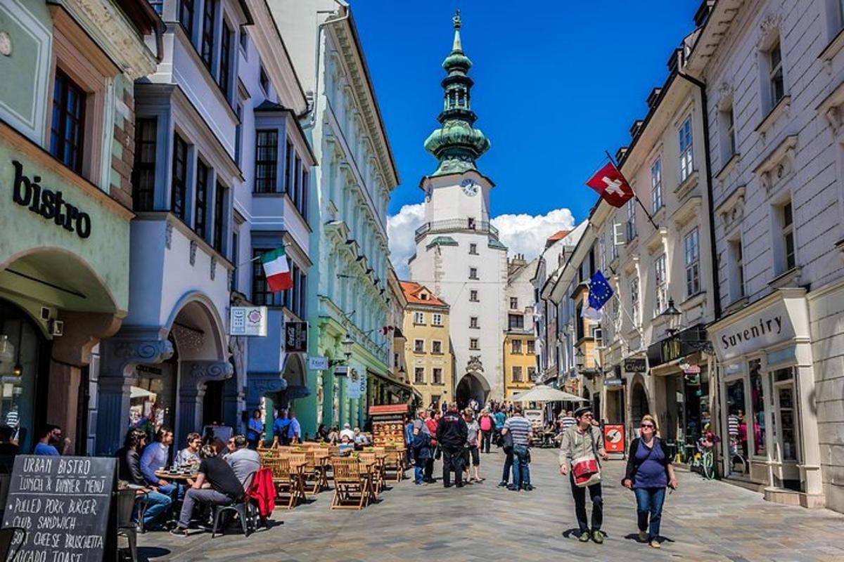 a group of people walking down a street with a clock tower