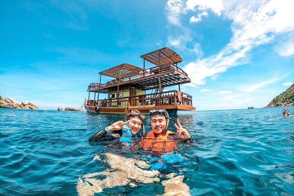 a man and woman in the water in front of a boat