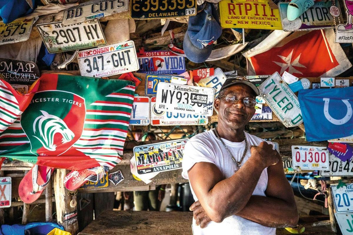 um homem parado em frente a uma pilha de placas de rua