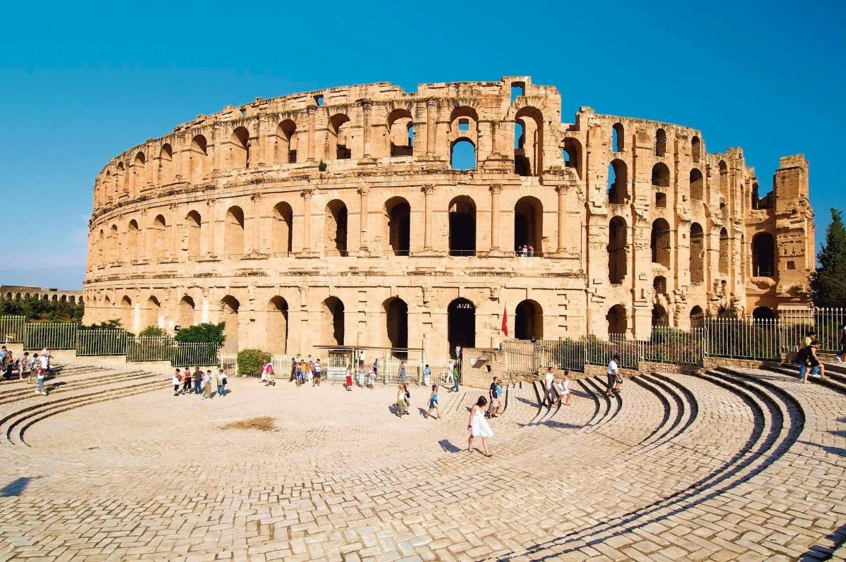 Un grupo de personas caminando por el coliseo.