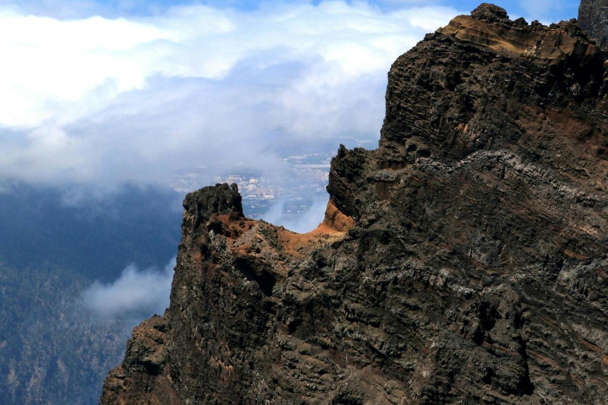 a rocky mountain with clouds in the sky