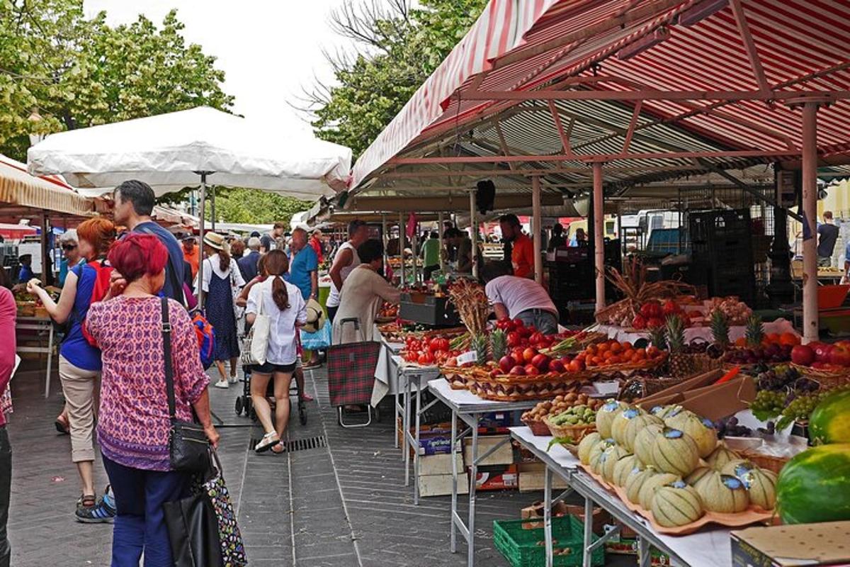 eine Gruppe von Menschen, die mit Obst und Gemüse über einen Markt gehen