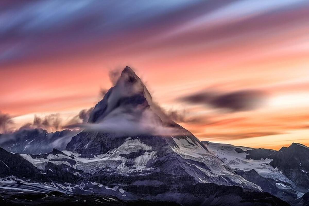 una montagna coperta di neve sotto un cielo nuvoloso