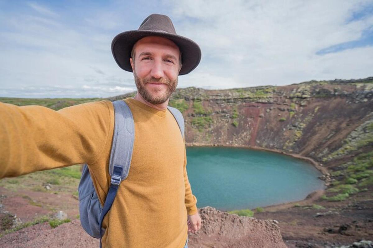 um homem usando um chapéu em pé ao lado de um lago