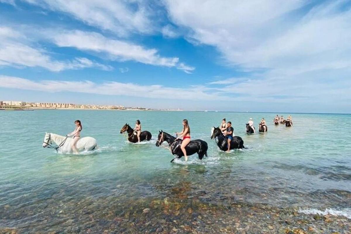 مجموعة من الأشخاص يركبون الخيول في الماء