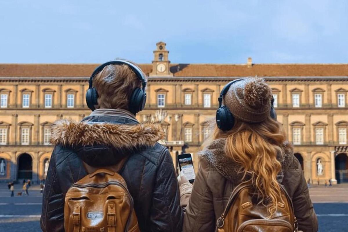 dues persones amb auriculars mirant un edifici
