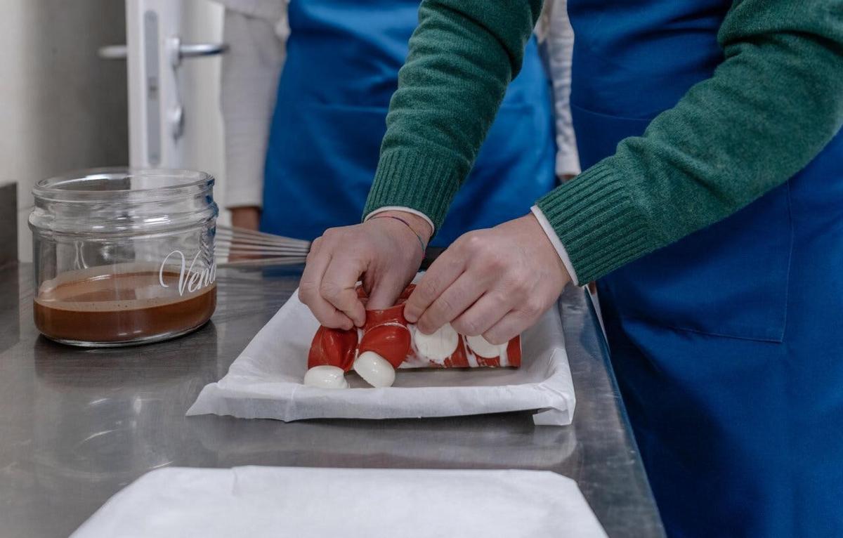 inimene valmistab laual hot dogi