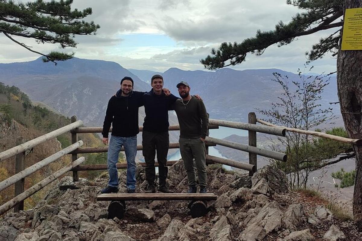 a group of three men standing on top of a mountain