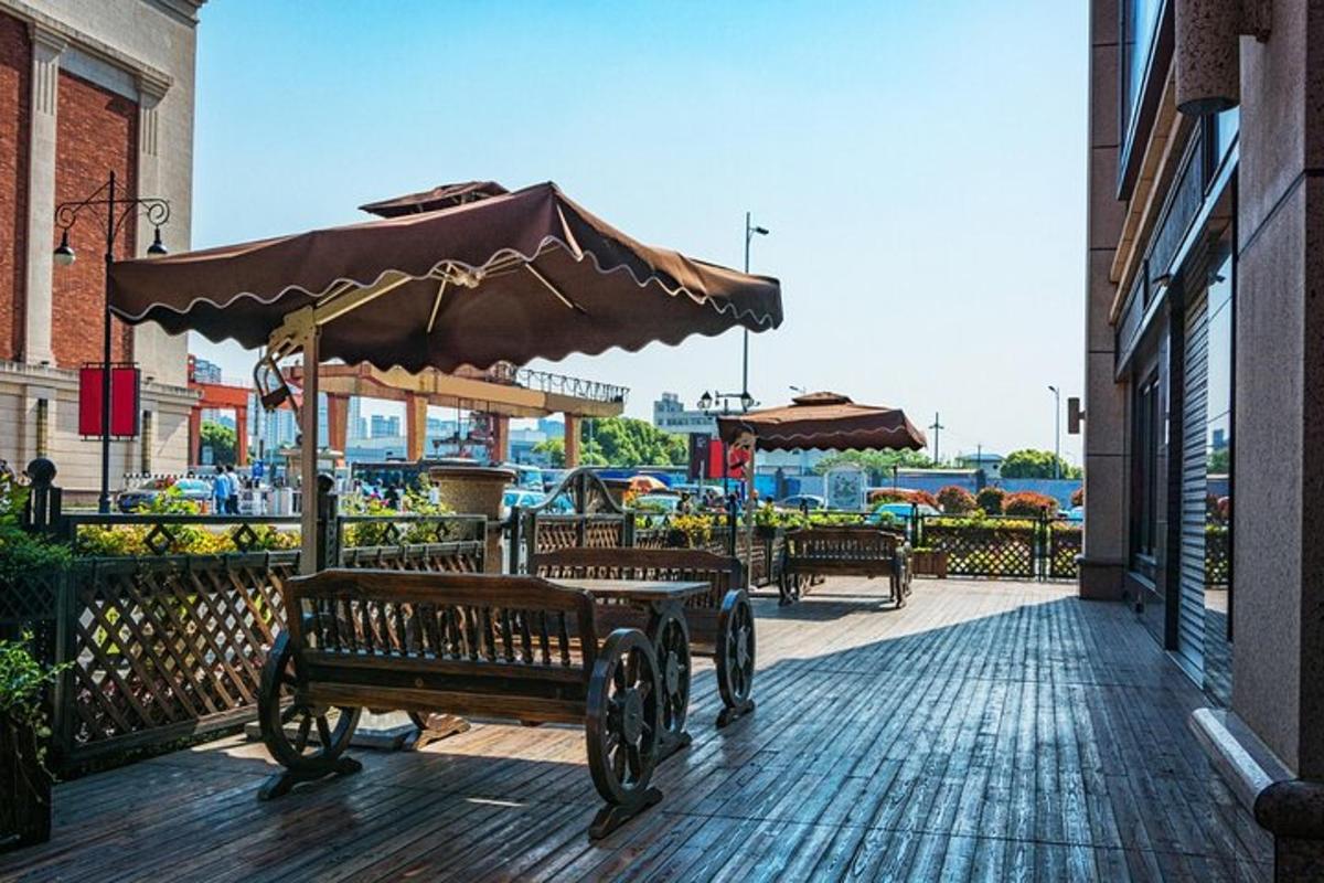 Un patio con una mesa, una sombrilla y bancos.