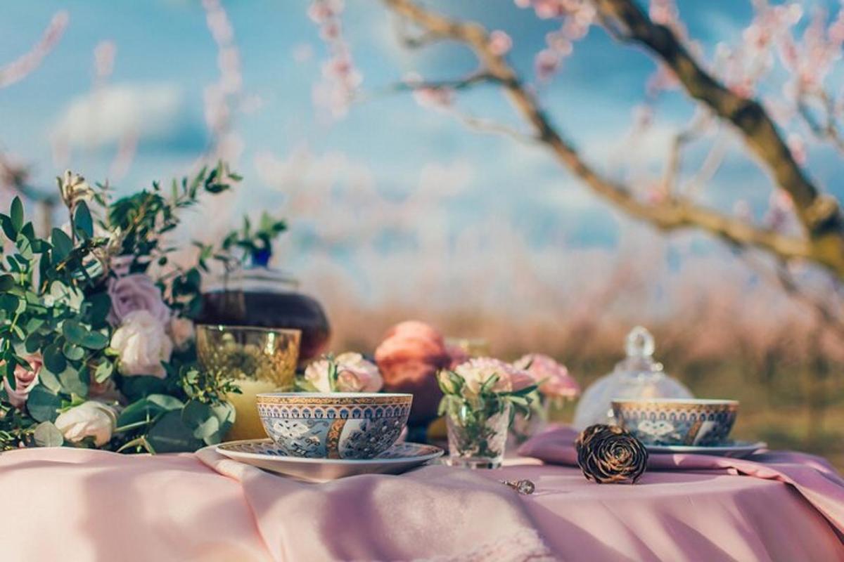 a table with two tea cups and flowers on it