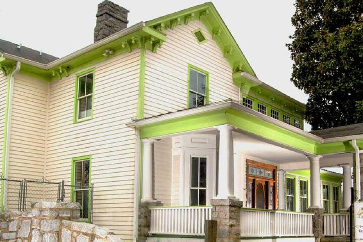 an old white house with a green roof