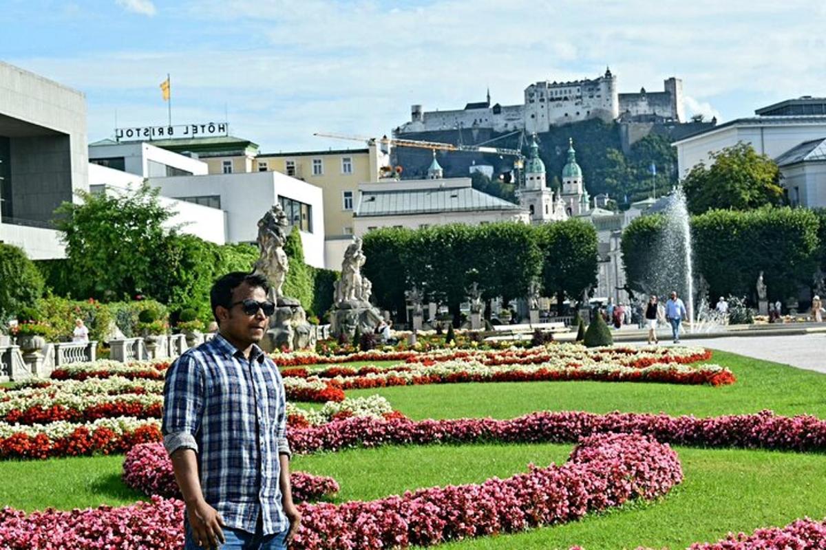 Un hombre parado frente a un jardín de flores.