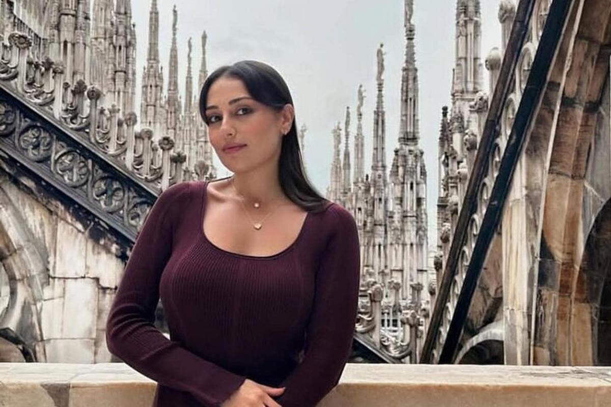 una donna in piedi su un balcone di fronte a una cattedrale