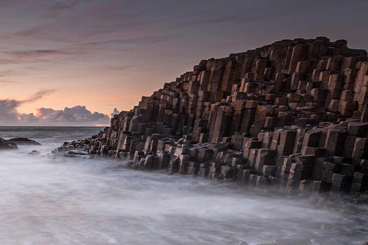 a large rock wall on the beach in the ocean