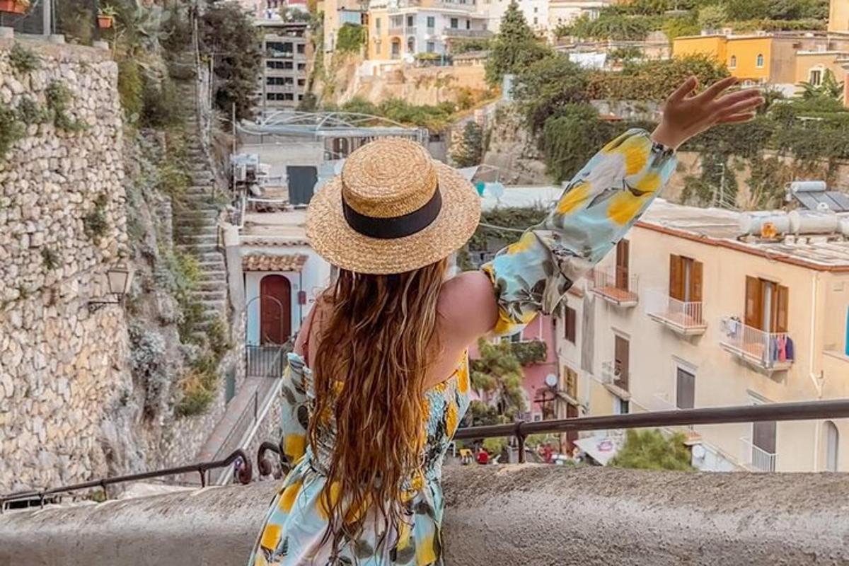 una donna con un cappello di paglia che guarda verso una città