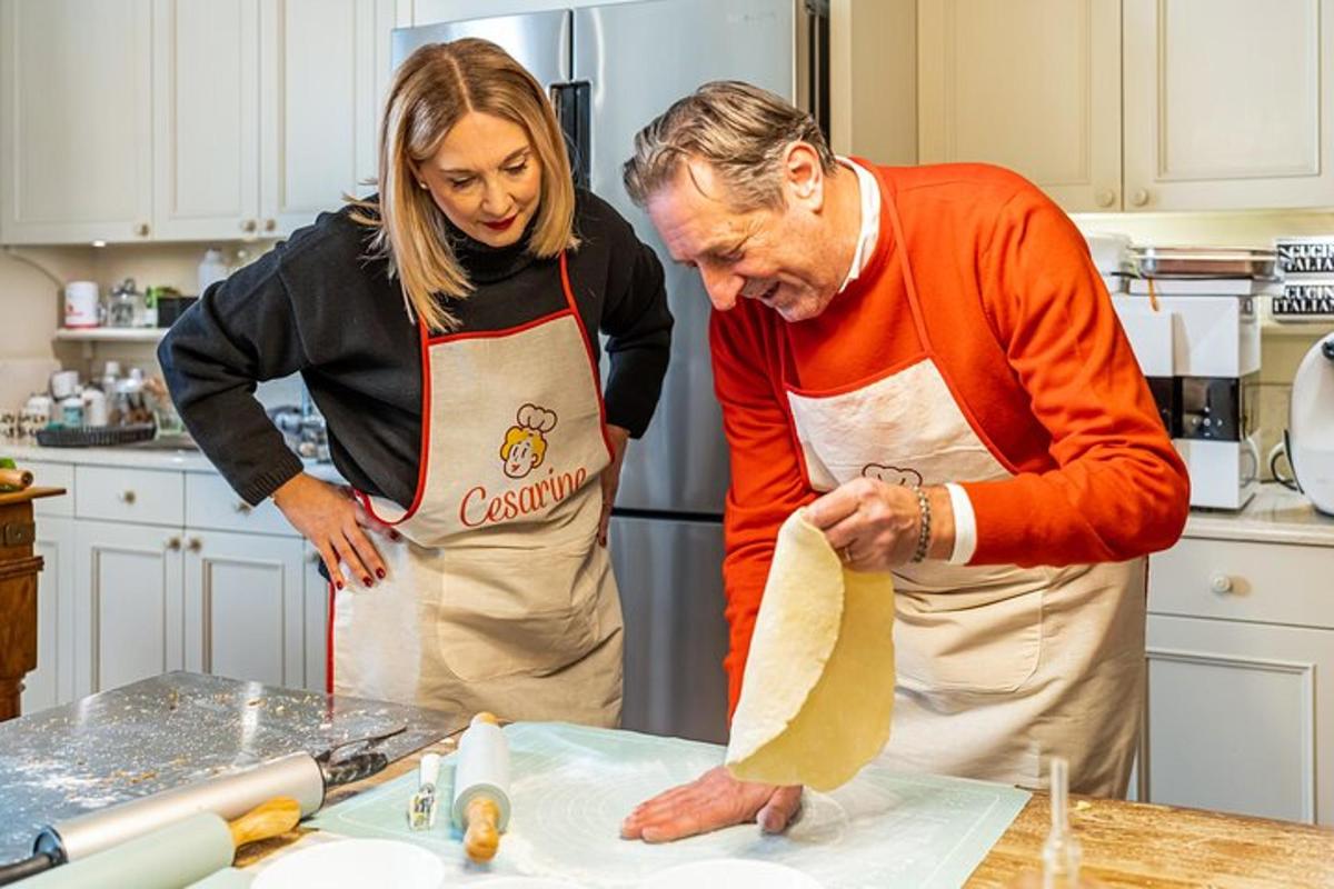 un uomo e una donna in cucina che impastano la pasta