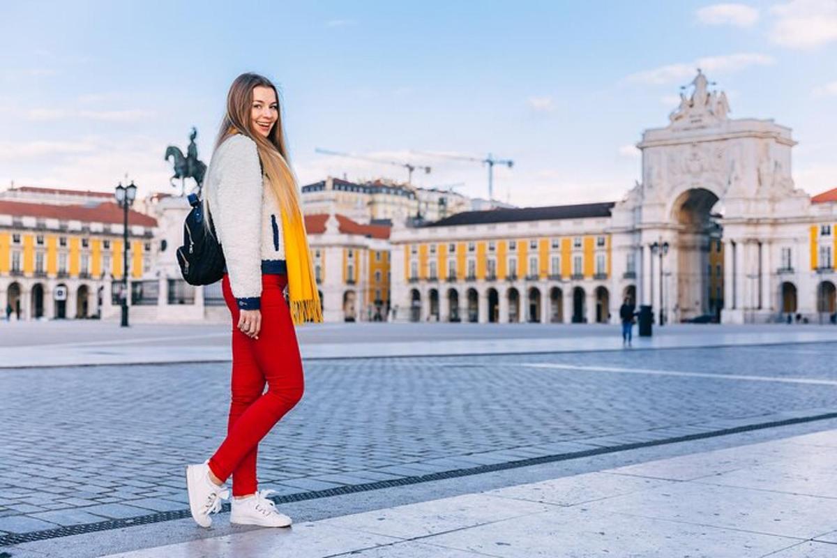 Egy piros nadrágos és sárga sálas nő áll az utcán