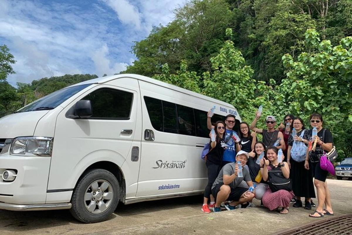 a group of people posing in front of a van