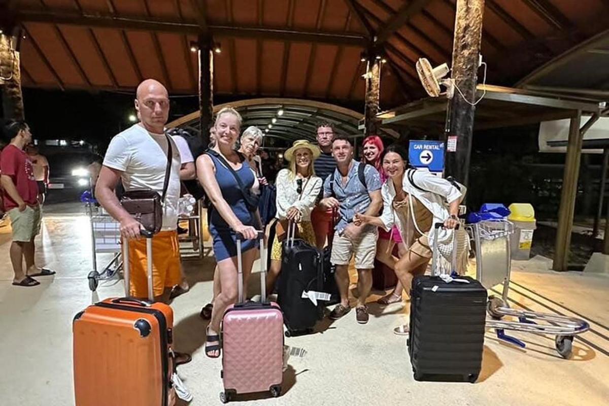 a group of people posing for a picture with their luggage