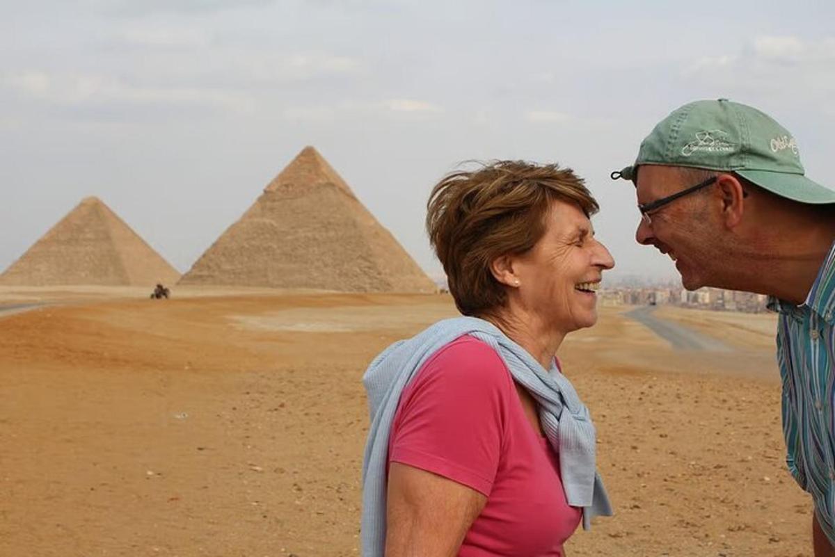 a man and a woman standing in front of the pyramids