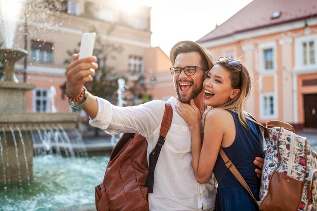 a man and a woman taking a picture of a fountain