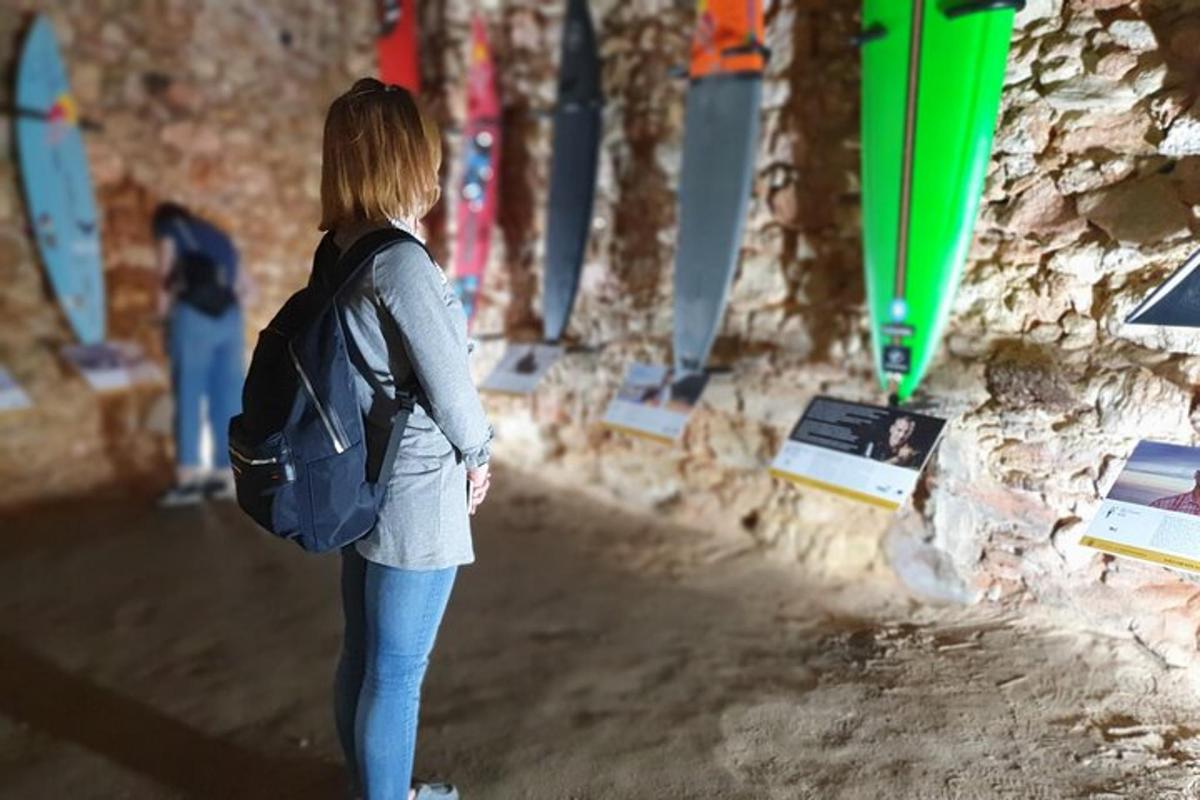 Una mujer con una mochila de pie junto a una pared.