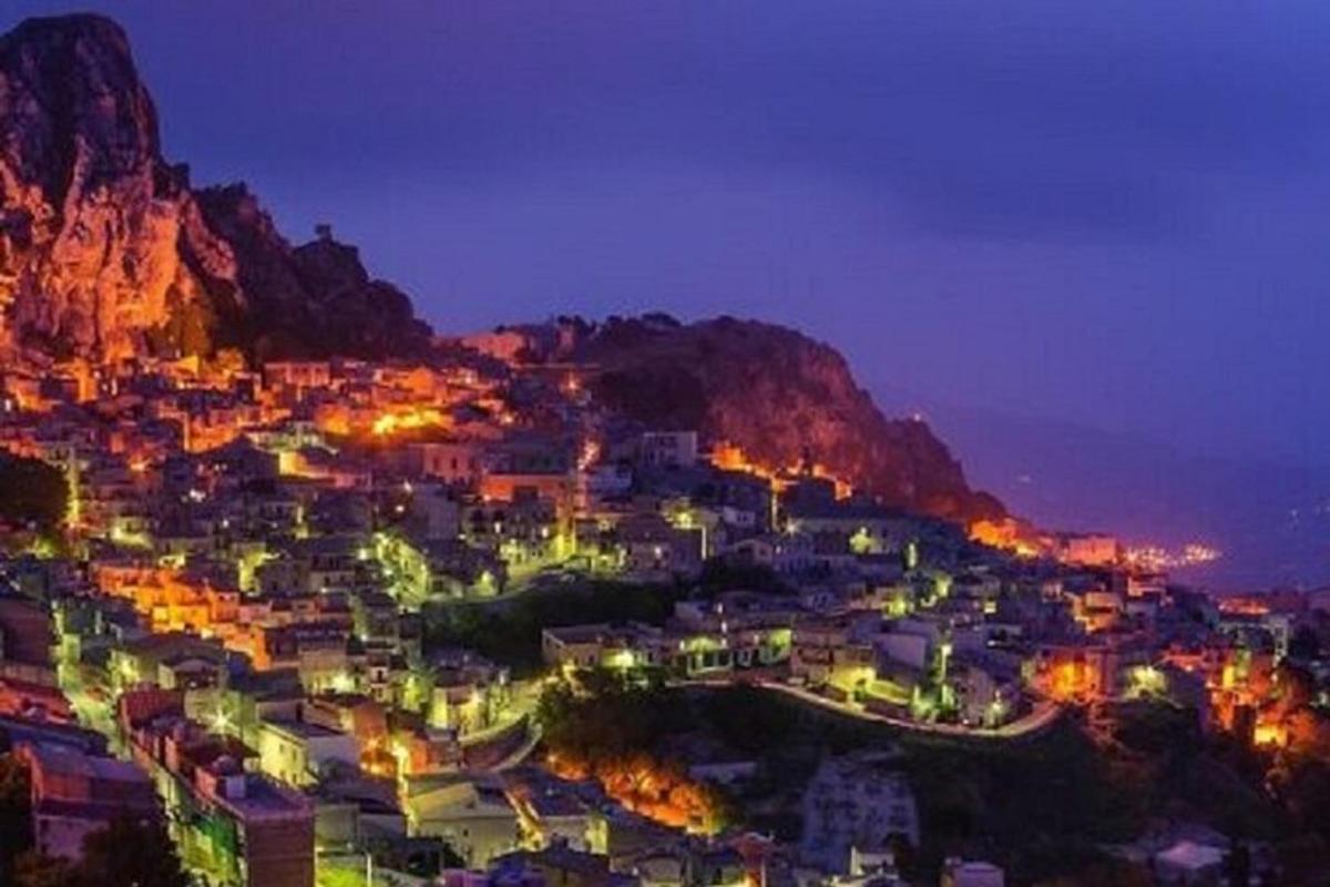 a city lit up at night with a mountain