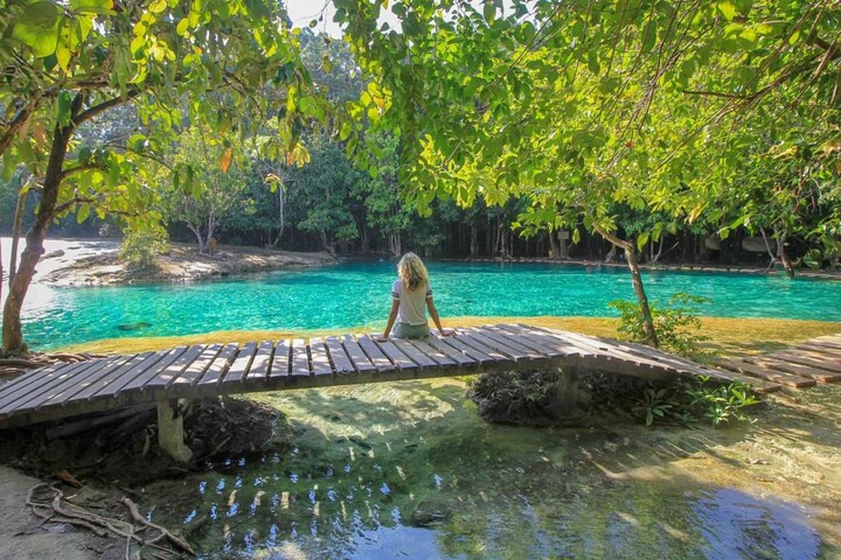 una donna seduta su un ponte di legno sopra un fiume
