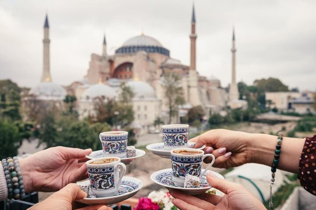 un grup de persones amb tasses de cafè davant d'una mesquita