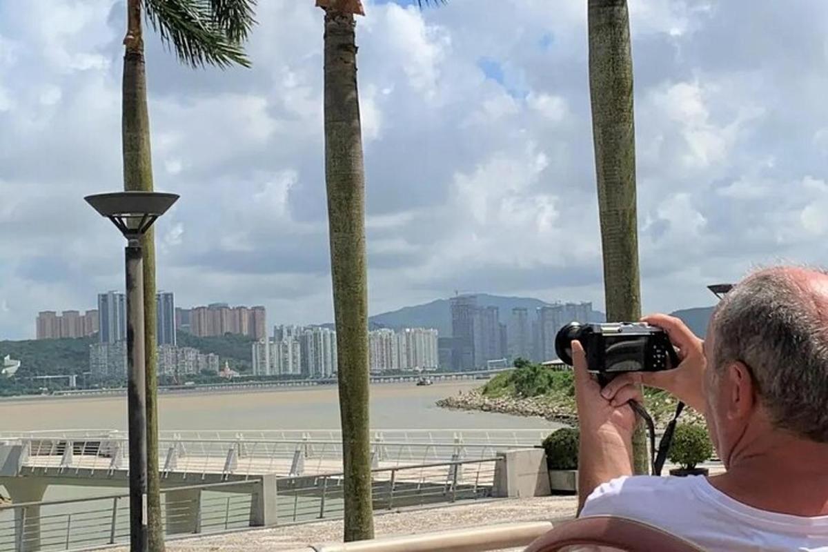 카메라로 강 사진을 찍는 남자