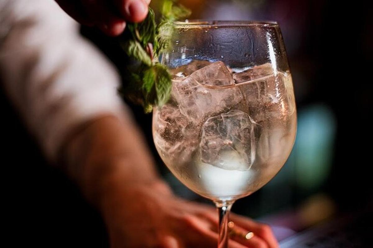 una persona che tiene in mano un bicchiere con una bevanda
