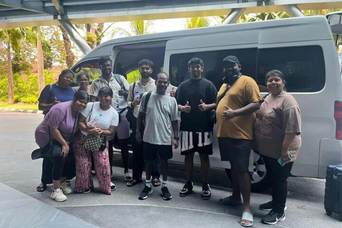 um grupo de pessoas em pé na frente de uma van