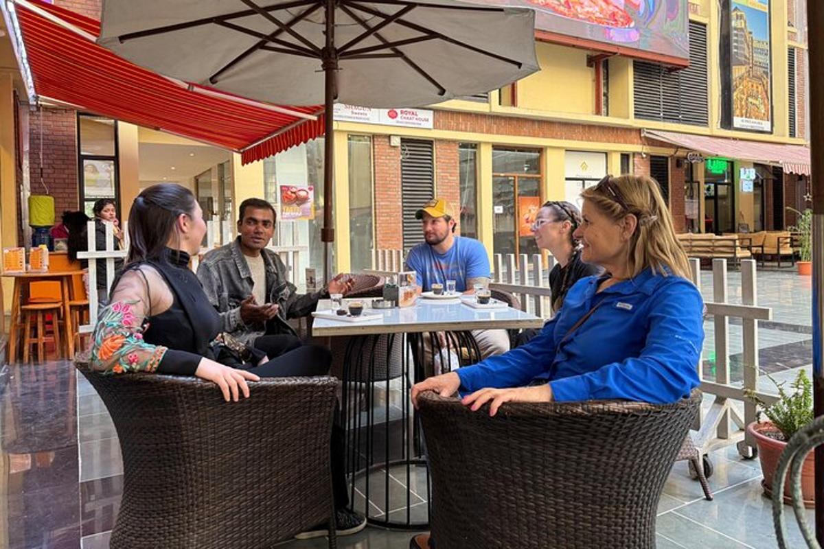 skupina lidí sedících u stolu před restaurací