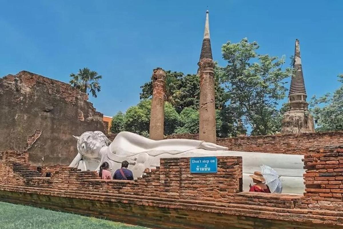 un gruppo di persone in piedi davanti a una statua